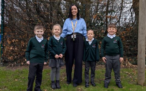 Rebecca stood with four children against wooded area
